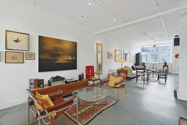 living room featuring baseboards and concrete floors