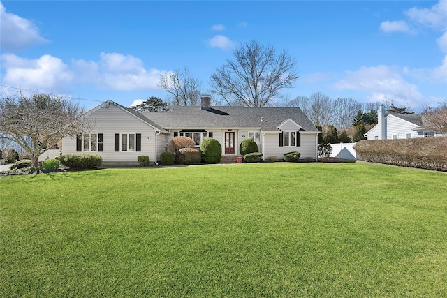 view of front of house featuring a chimney, a front yard, and fence