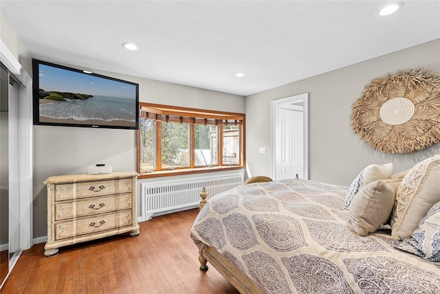 bedroom with hardwood / wood-style floors, radiator, and recessed lighting