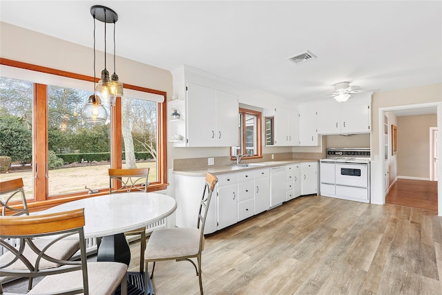 kitchen with white appliances, a ceiling fan, visible vents, light countertops, and white cabinets