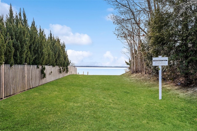 view of yard with a water view and fence