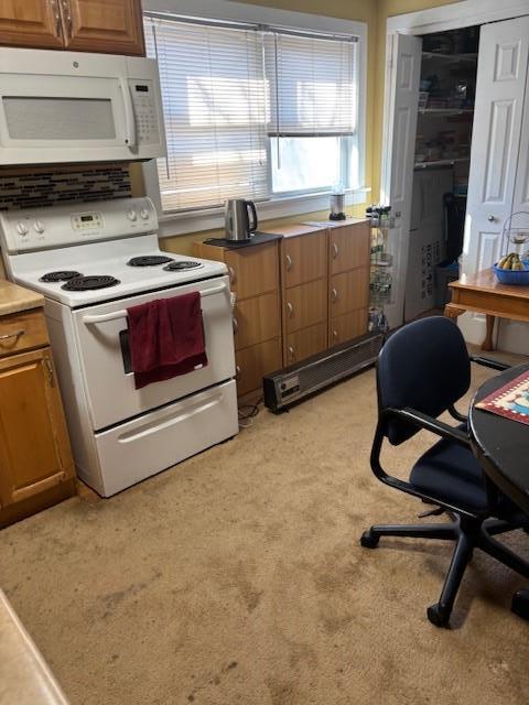 kitchen with brown cabinetry, white appliances, and light countertops