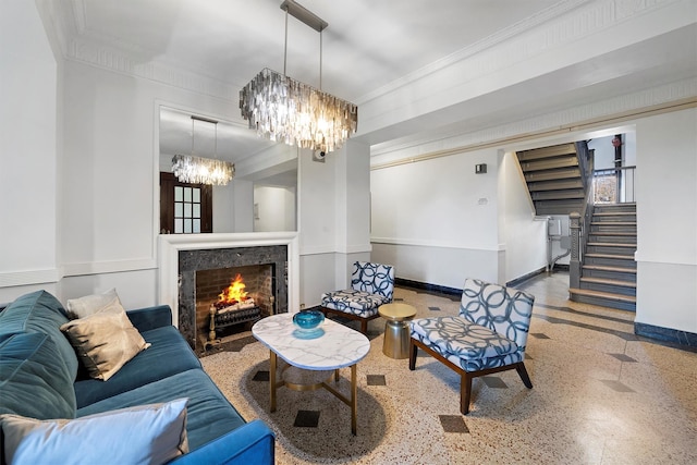 living area featuring crown molding, stairway, a high end fireplace, a chandelier, and baseboards