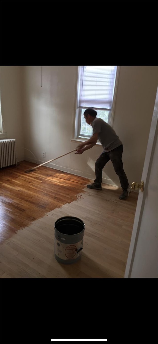 interior space with radiator and wood finished floors