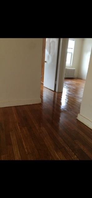 unfurnished room featuring wood finished floors and baseboards