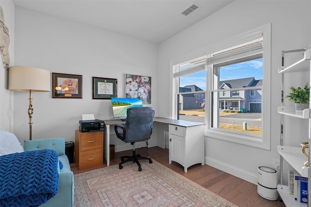 office space with light wood-style flooring, baseboards, and visible vents