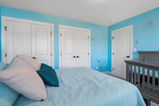 bedroom featuring baseboards and two closets