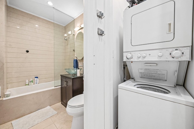 laundry area with stacked washing maching and dryer, laundry area, and tile patterned floors