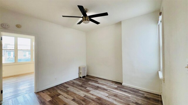 10634 Sutphin Blvd, Jamaica, NY 11435 - spare room with baseboards, a ceiling fan, radiator, and wood finished floors