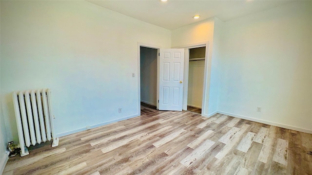10634 Sutphin Blvd, Jamaica, NY 11435 - unfurnished bedroom with baseboards, light wood finished floors, radiator, and recessed lighting