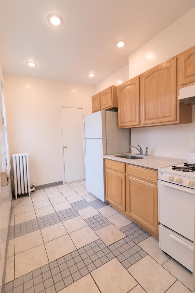10634 Sutphin Blvd, Jamaica, NY 11435 - kitchen with white appliances, radiator heating unit, under cabinet range hood, a sink, and light brown cabinets