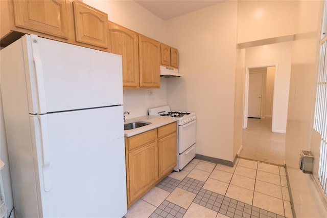 10634 Sutphin Blvd, Jamaica, NY 11435 - kitchen with light tile patterned floors, white appliances, under cabinet range hood, a sink, and light countertops