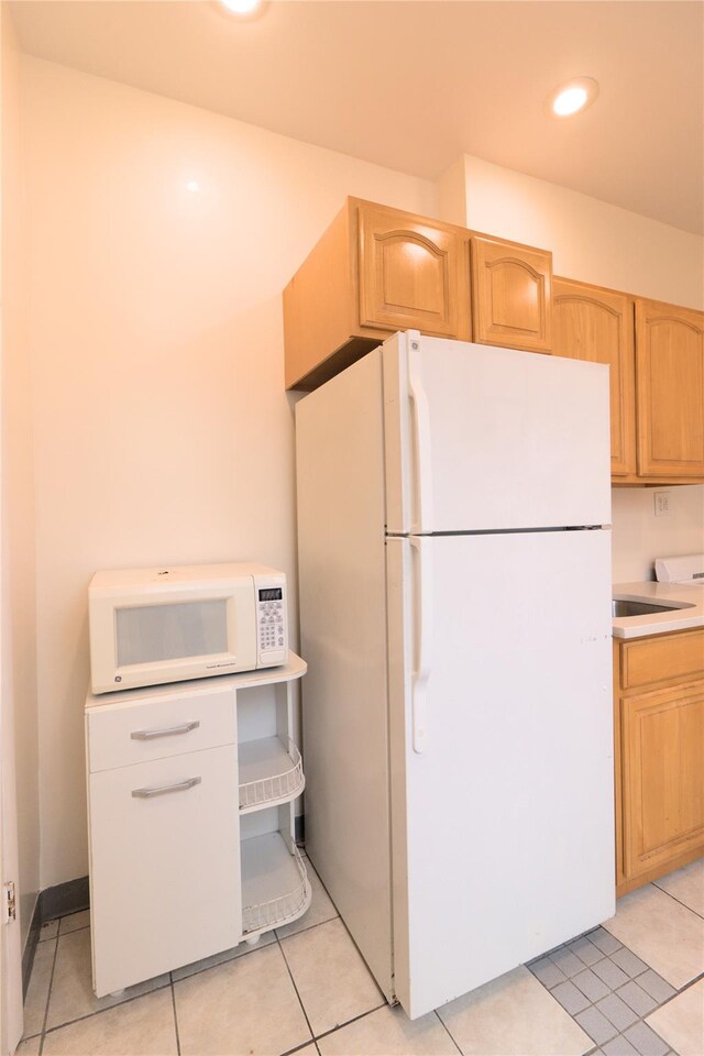10634 Sutphin Blvd, Jamaica, NY 11435 - kitchen with light tile patterned floors, white appliances, light brown cabinetry, recessed lighting, and light countertops