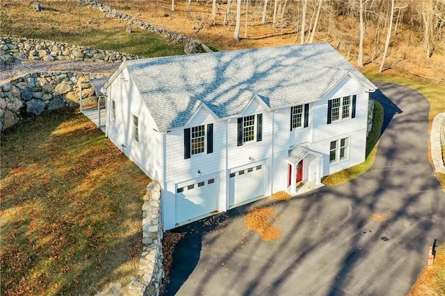 view of front of house featuring a shingled roof, driveway, and an attached garage