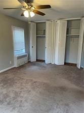 unfurnished bedroom featuring multiple closets and a ceiling fan