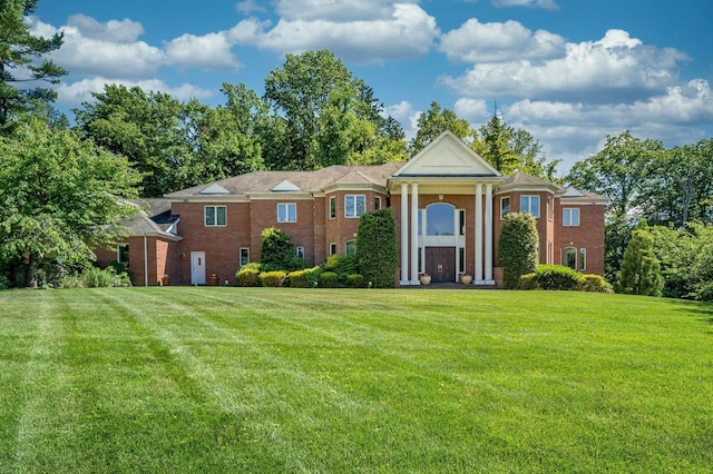 neoclassical home with brick siding and a front lawn