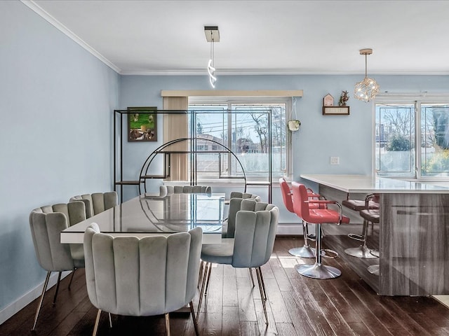 dining room with baseboards, hardwood / wood-style floors, a dry bar, and crown molding