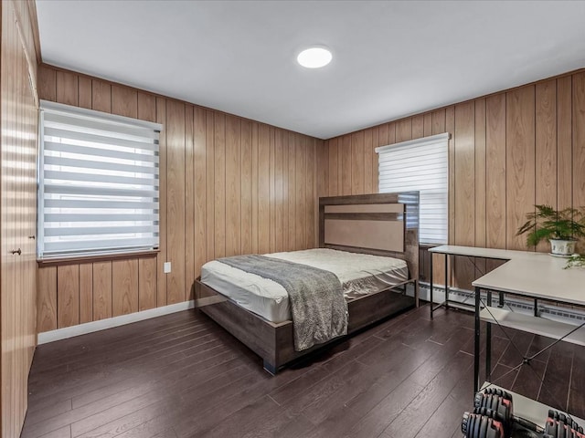 bedroom with baseboards and dark wood-type flooring