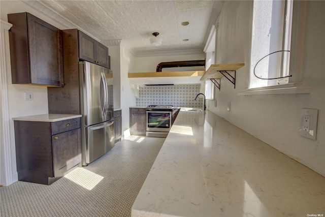 kitchen with dark brown cabinetry, appliances with stainless steel finishes, a sink, open shelves, and backsplash