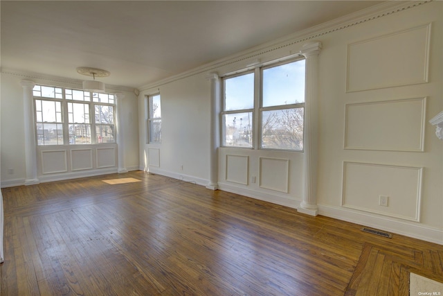 unfurnished room featuring visible vents, plenty of natural light, and ornate columns