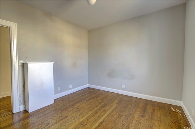 empty room with baseboards and wood finished floors