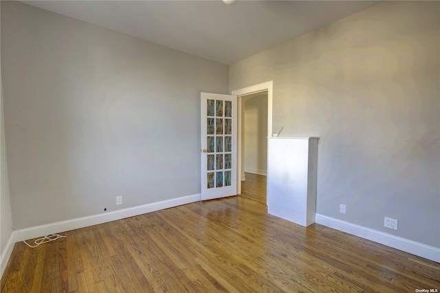 empty room with baseboards and wood finished floors
