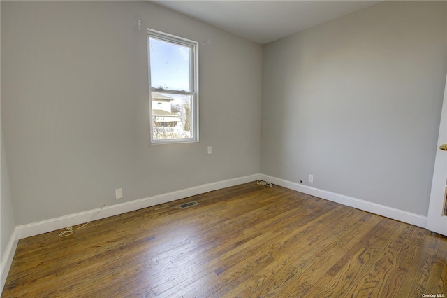 unfurnished room with wood finished floors and baseboards