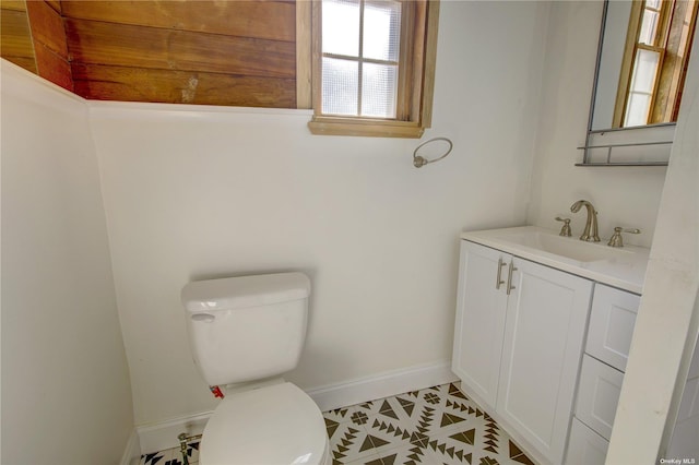 bathroom featuring toilet, baseboards, and vanity