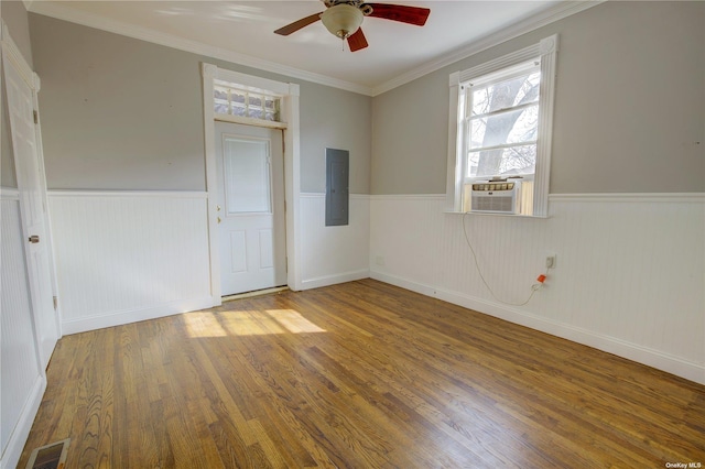 spare room featuring a wainscoted wall, electric panel, visible vents, and wood finished floors