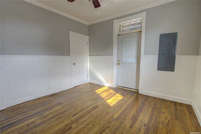 unfurnished room with electric panel, a wainscoted wall, ceiling fan, wood finished floors, and crown molding
