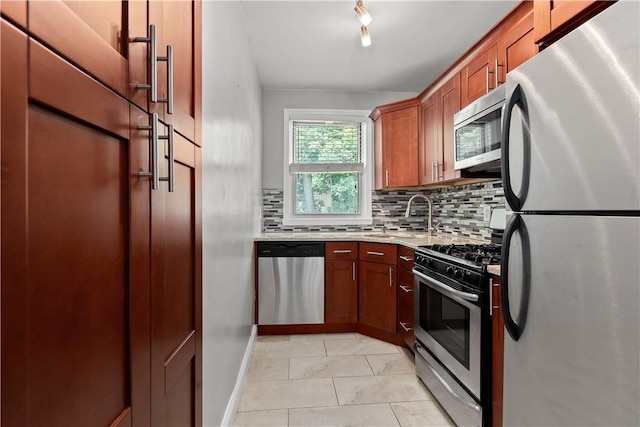 kitchen with a sink, stainless steel appliances, brown cabinetry, light tile patterned floors, and decorative backsplash