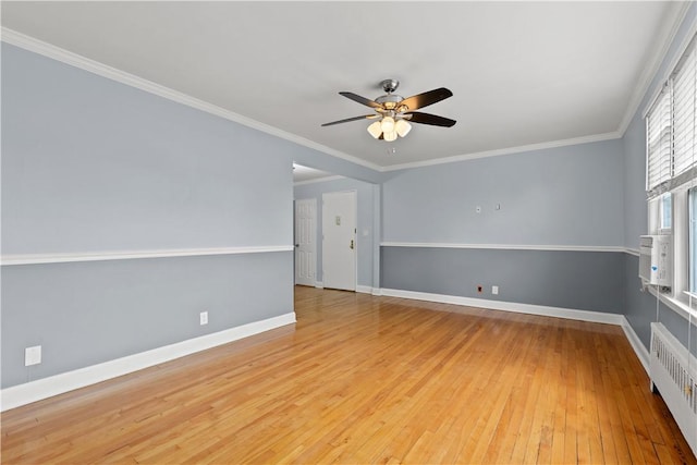 empty room featuring radiator, baseboards, ceiling fan, ornamental molding, and light wood-type flooring