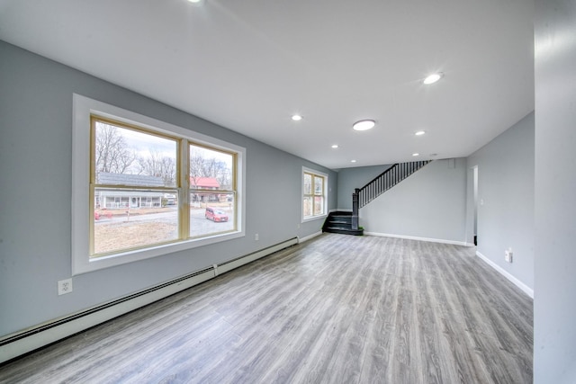 unfurnished living room featuring wood finished floors, recessed lighting, stairway, baseboards, and baseboard heating