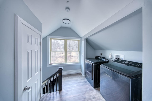 laundry room featuring washer and dryer, baseboards, laundry area, and light wood finished floors