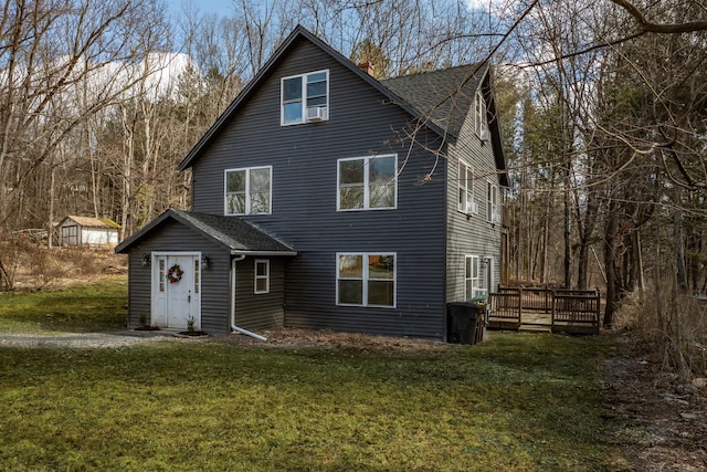 rustic home featuring a deck, a front lawn, and roof with shingles