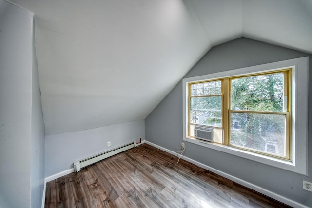 additional living space featuring vaulted ceiling, wood finished floors, baseboards, and a baseboard radiator