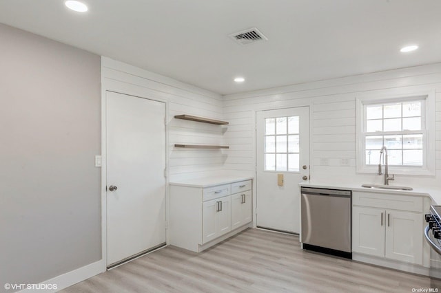 kitchen featuring visible vents, light wood finished floors, a sink, light countertops, and dishwasher