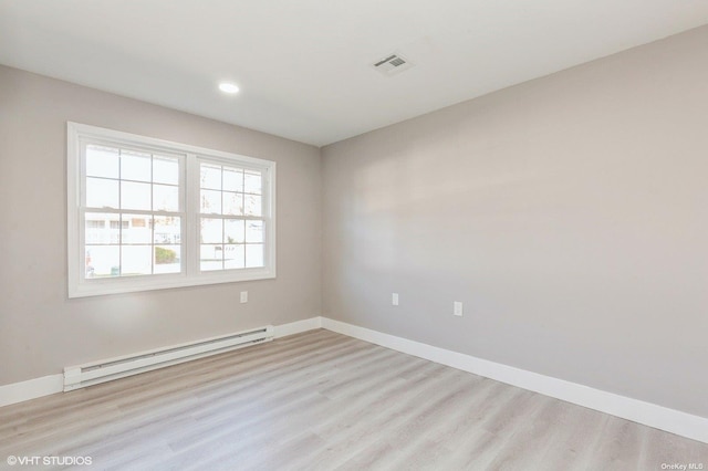 spare room with visible vents, wood finished floors, recessed lighting, a baseboard radiator, and baseboards