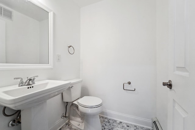 bathroom with visible vents, a baseboard heating unit, baseboards, toilet, and a sink