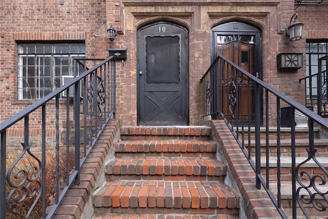 doorway to property featuring brick siding