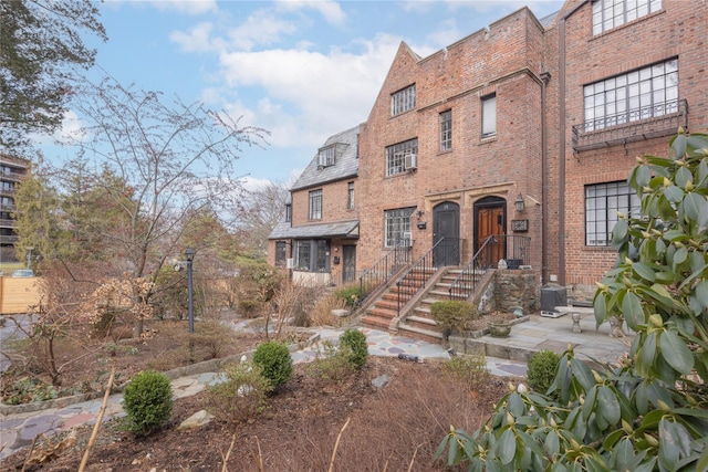 view of front of property with a high end roof and brick siding