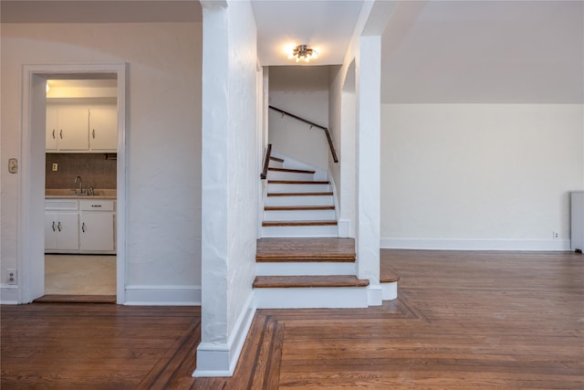 staircase with baseboards and wood finished floors