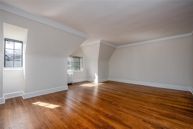 bonus room featuring a wealth of natural light, baseboards, radiator, and wood finished floors