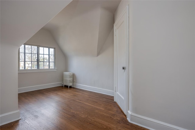 bonus room with vaulted ceiling, radiator, wood finished floors, and baseboards