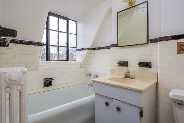 bathroom featuring a bathing tub, toilet, tile walls, and vanity