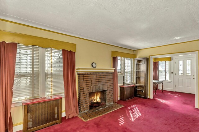 unfurnished living room with a brick fireplace, a textured ceiling, radiator heating unit, and carpet