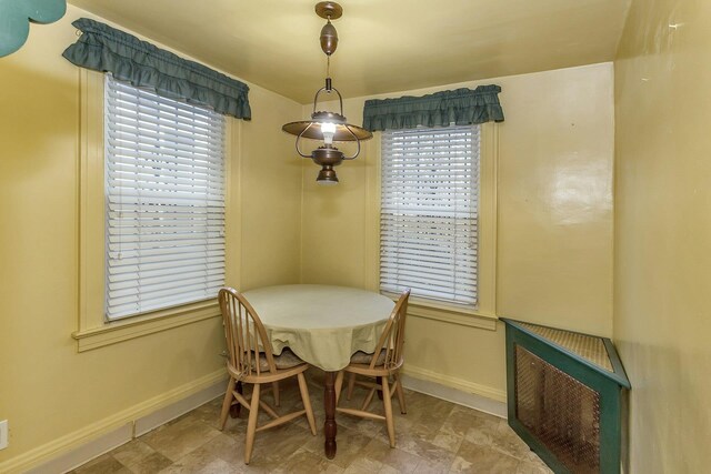 dining room with heating unit, baseboards, and a healthy amount of sunlight