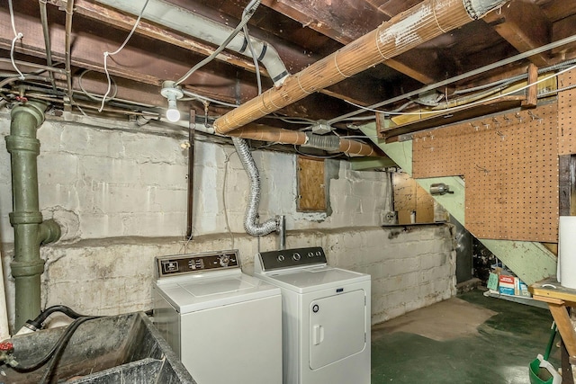 washroom with a sink, laundry area, and washer and clothes dryer