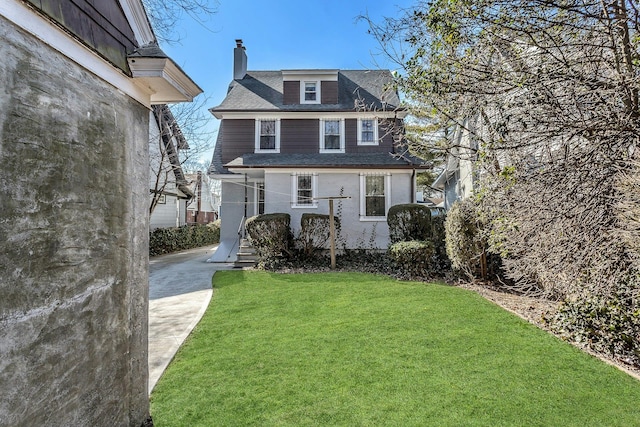 view of front of property featuring a chimney and a front lawn