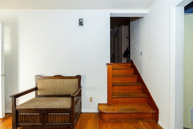 stairs featuring wood finished floors and baseboards